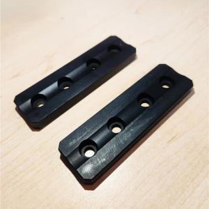 Pair of black precision-machined steel loose weight blocks for rifle chassis M-LOK systems.