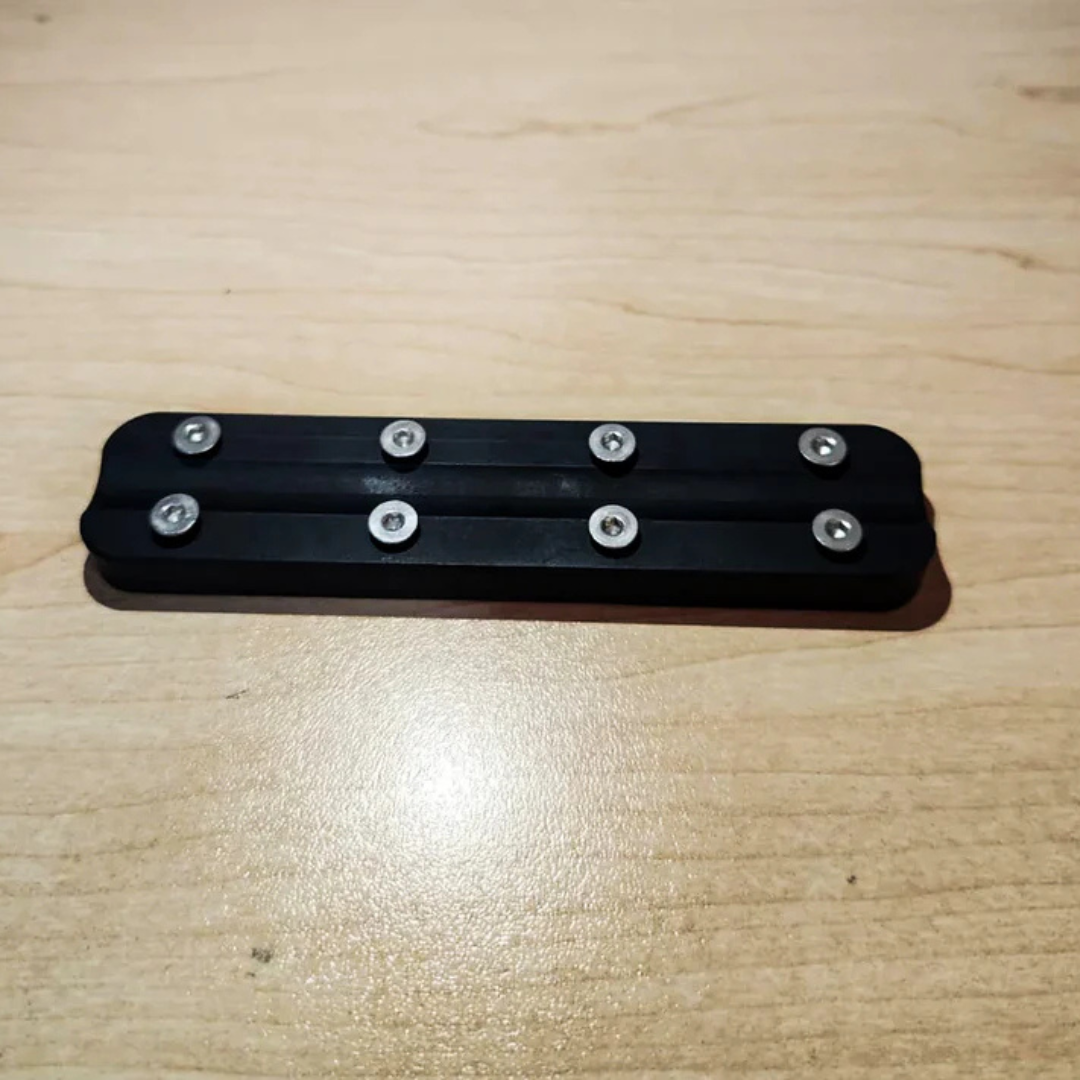 Top-down view of black loose weight blocks assembled with stainless steel mounting screws.